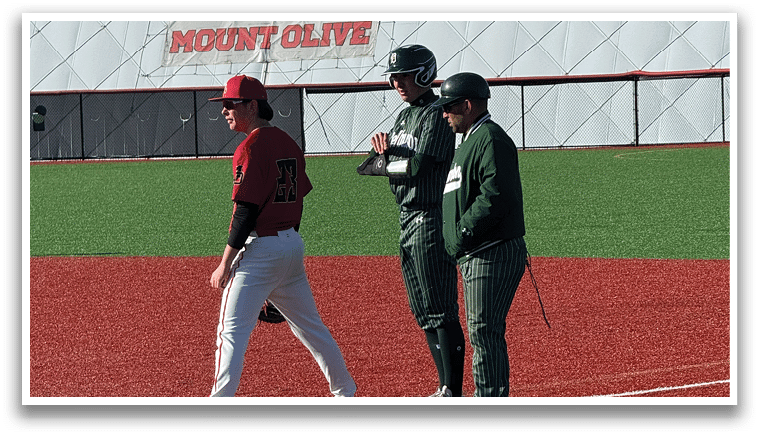 A baseball field with a man and woman walking on it. Description generated by AI
