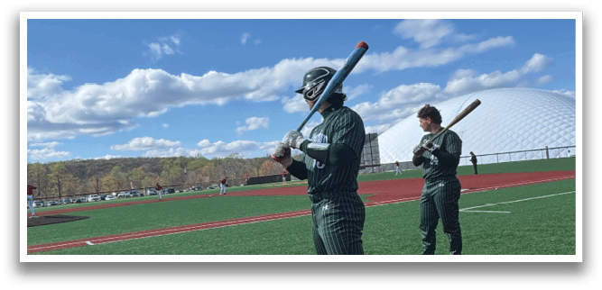 A baseball player holding a bat on a field. Description generated by AI