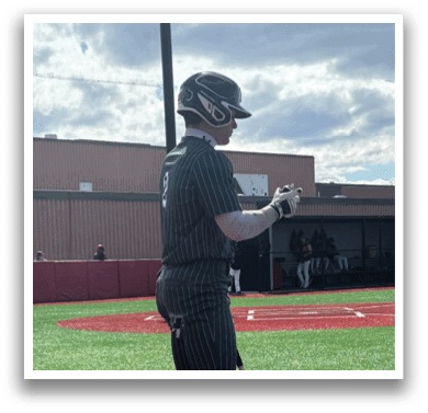 A baseball player holding a bat on a field. Description generated by AI