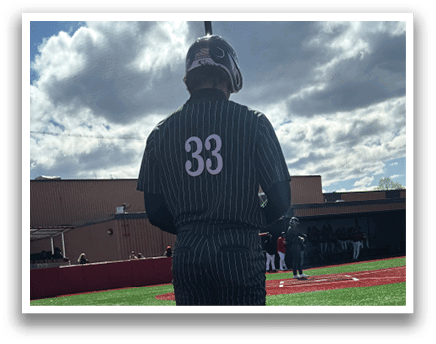 A baseball player wearing a green and white uniform. Description generated by AI