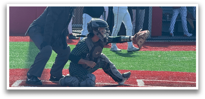 A baseball player is holding a bat, ready to swing. Description generated by AI