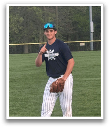 A man in a blue shirt and white pants is standing on a baseball field. Description generated by AI