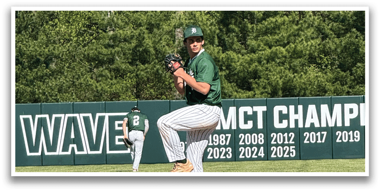 A baseball player in a green shirt and white pants is pitching a ball. Description generated by AI