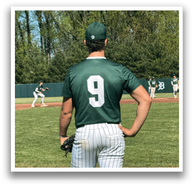 A baseball player wearing a green and white uniform with the number 9 on the back. Description generated by AI