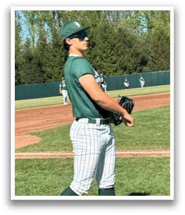 A baseball player wearing a green shirt and white socks. Description generated by AI