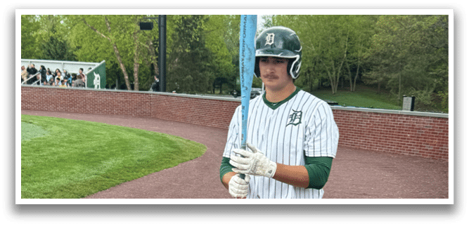 A baseball player holding a bat. Description generated by AI
