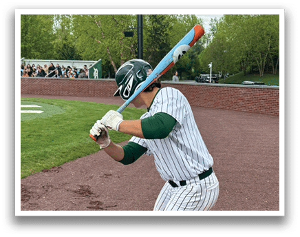 A baseball player in a green and white uniform is swinging a bat. Description generated by AI