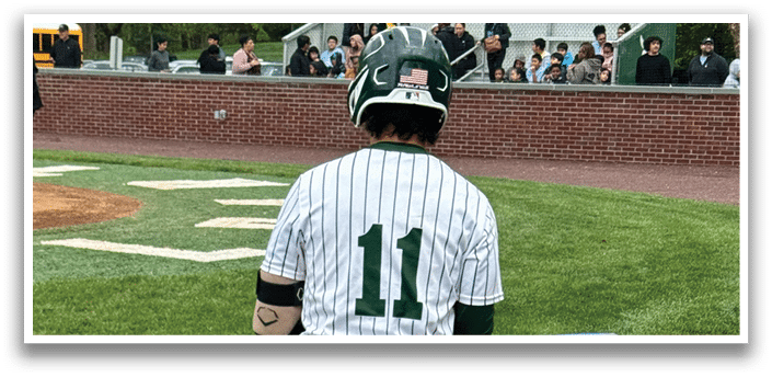 A baseball player wearing a green and white uniform with the number 11 on the back. Description generated by AI