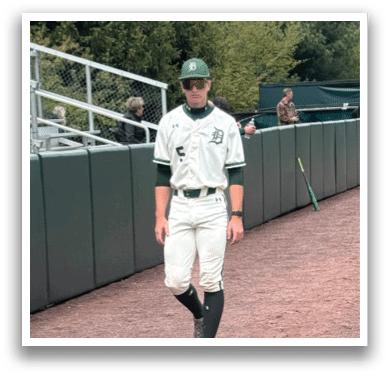 A man wearing a baseball uniform is walking down a dirt road. Description generated by AI