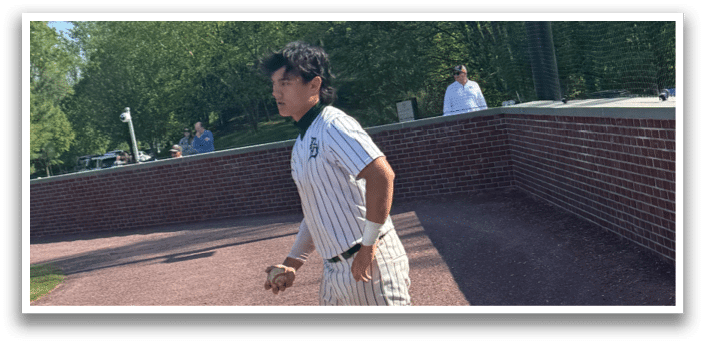 Two baseball players kneeling on the grass. Description generated by AI