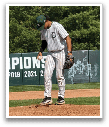 A baseball player is standing on the pitcher's mound. Description generated by AI