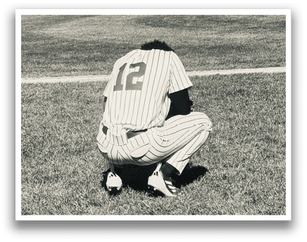 A baseball player kneeling on the field. Description generated by AI