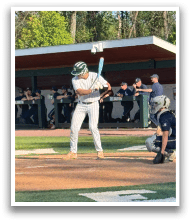 A baseball player is swinging a bat on a field. Description generated by AI