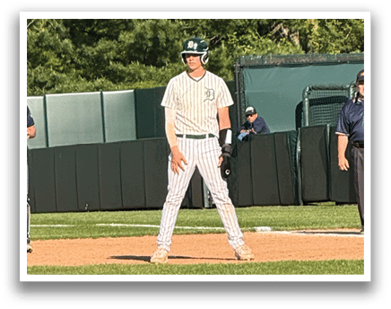 A baseball field with a man standing at home plate. Description generated by AI