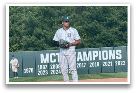 A baseball player standing on the pitcher's mound. Description generated by AI