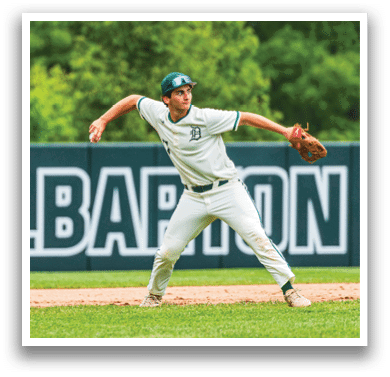 A baseball player wearing a white uniform and a green hat. Description generated by AI