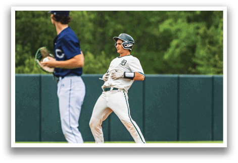 A baseball player wearing a blue shirt and white pants. Description generated by AI