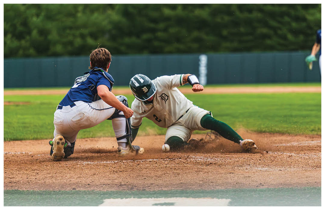 A baseball player sliding into home plate. Description generated by AI