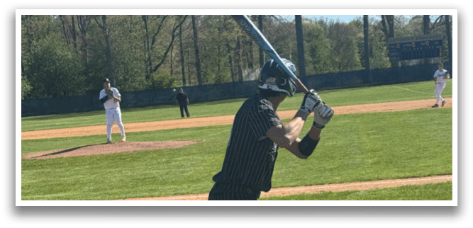 A baseball player is holding a bat and getting ready to swing. Description generated by AI