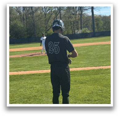 A baseball player wearing a black and white uniform with the number 25 on the back. Description generated by AI