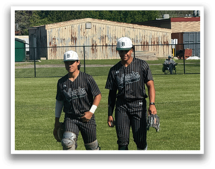 Two baseball players walking on a field. Description generated by AI