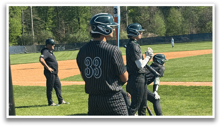 A baseball player wearing a black and white uniform stands on the field. Description generated by AI