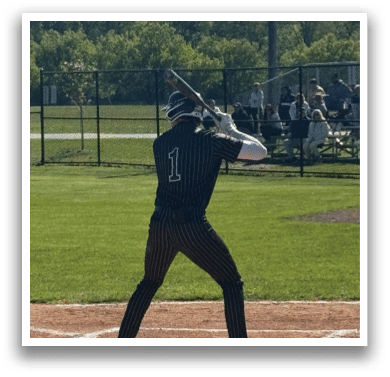 A baseball player is swinging a bat on a field. Description generated by AI
