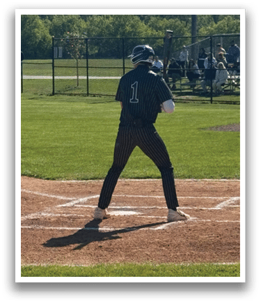 A baseball player is swinging a bat on a field. Description generated by AI