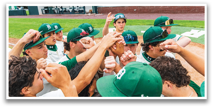 A group of baseball players wearing green hats and white uniforms. Description generated by AI