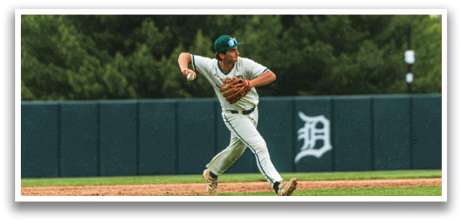 A baseball player wearing a green hat and white uniform is running towards a base. Description generated by AI
