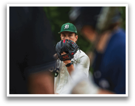 A group of baseball players wearing green hats and white uniforms. Description generated by AI