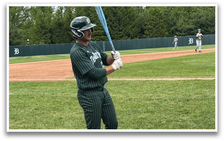 A baseball player holding a bat. Description generated by AI