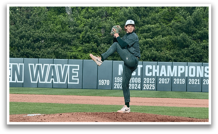 A baseball player in a green shirt and white pants is pitching a ball. Description generated by AI
