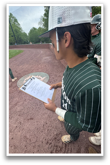 A baseball player holding a clipboard. Description generated by AI