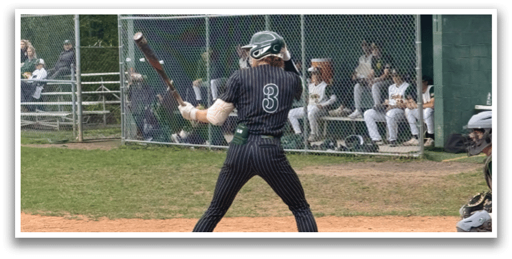 A baseball player is at bat, holding a bat and waiting for the pitch. Description generated by AI