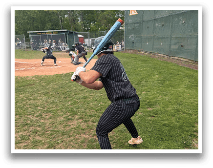 A baseball player is holding a bat and getting ready to swing. Description generated by AI