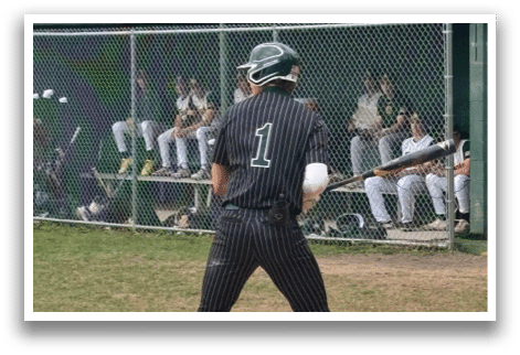 A baseball player is at bat, wearing a black and white uniform. Description generated by AI