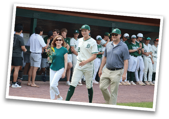 A man and woman walking on a baseball field. Description generated by AI