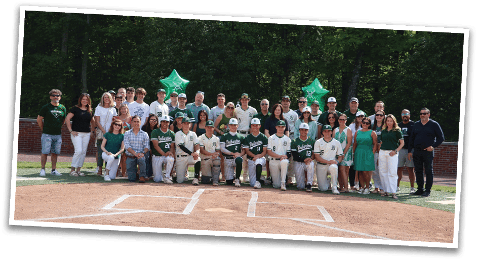 A group of people posing for a picture on a baseball field. Description generated by AI
