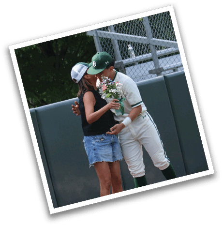 A man and woman are standing on a baseball field. Description generated by AI