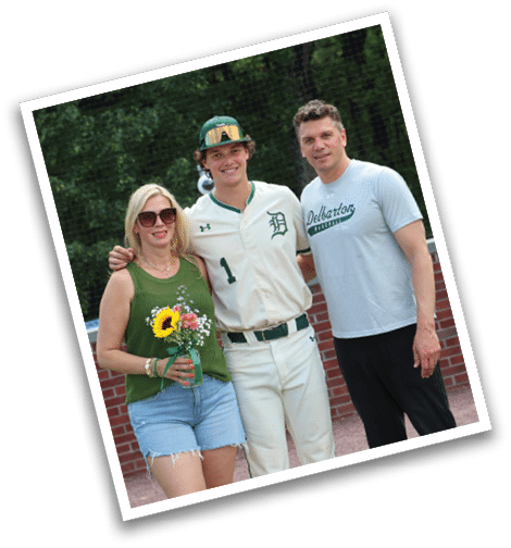 A man and woman standing on a baseball field with a baseball player in the middle. Description generated by AI