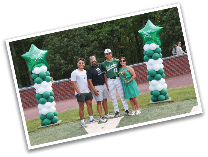 A group of people standing in front of a green and white banner. Description generated by AI