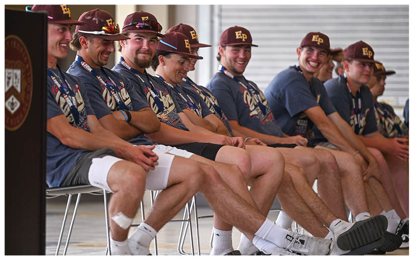 A group of football players on a field, one of them holding a football. AI generated content