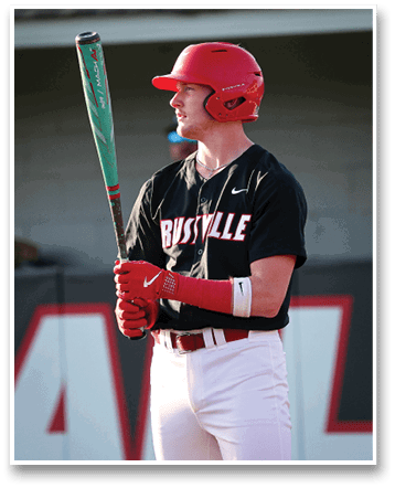 A baseball player wearing a red helmet and a black shirt with the word “Bustville" on it. He is holding a baseball bat and waiting for the pitch. AI generated content