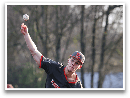 A baseball player in a black shirt and hat is pitching a ball. AI generated content
