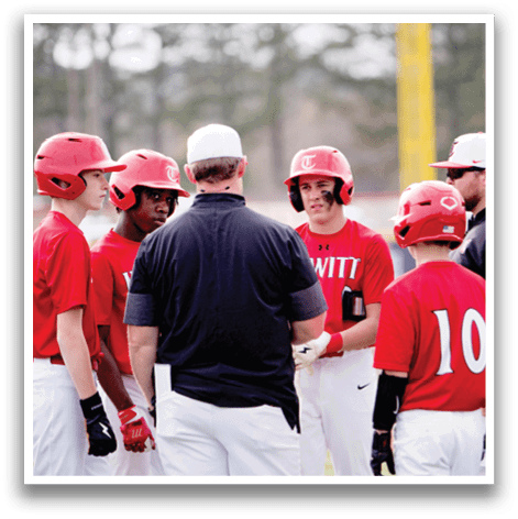 A group of young baseball players wearing red and white uniforms are standing on a field, engaged in conversation with a coach. AI generated content