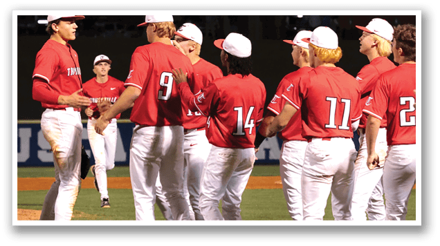 A group of baseball players wearing red shirts and white pants are hugging each other on the field. AI generated content