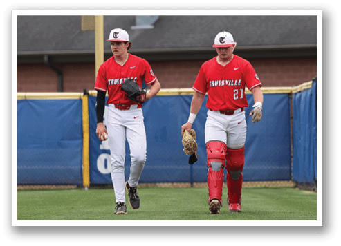 Two baseball players wearing red uniforms and white gloves are walking on a field. AI generated content