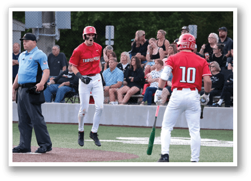 A baseball game is in progress with a player holding a bat and another player holding a baseball glove. The batter is swinging the bat, and the catcher is ready to catch the ball. There are several other players on the field, and a crowd of spectators is watching the game. AI generated content