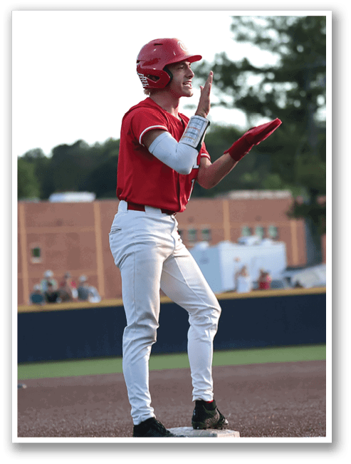 A baseball player in a red shirt and white pants is standing on home plate, holding a bat and getting ready to hit the ball. AI generated content